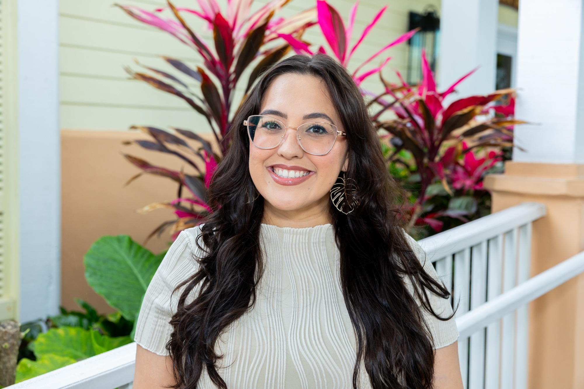 Headshot of the general manager standing infront of the restaurant with greenery behind her.